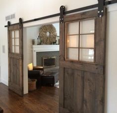 an open door leading to a living room with a fireplace in the corner and a chair next to it