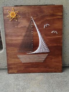 a wooden plaque with an image of a sailboat on it