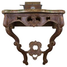 an ornate wooden table with a clock on top and two small drawers underneath the shelf