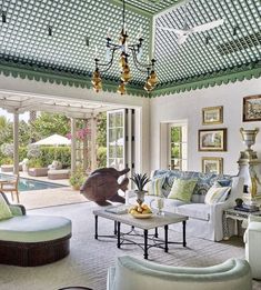 a living room filled with furniture next to a swimming pool