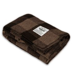 the brown and black plaid blanket is folded on top of each other, with a white tag