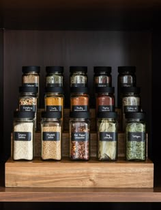 a wooden shelf filled with lots of different types of spices and seasonings on top of it