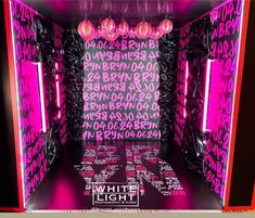 an empty room with neon lights and pink letters on the walls that read white light