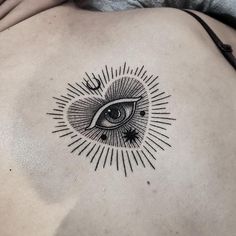 an eye tattoo on the back of a woman's left side ribcage