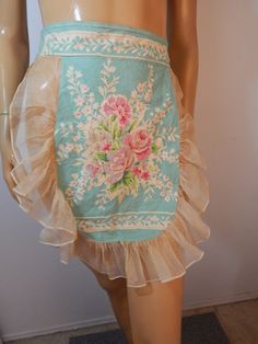 a mannequin wearing a blue skirt with pink flowers and ruffles on it