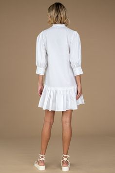 Say hi to our Chloe Dress, a new design we are sure you will obsess over. The Chloe Dress is a tunic-style swing silhouette featuring a slight high-low ruffle detailed skirt hem, giving her the ideal, flirty mini length. Ruffle detailing also trims the V-neckline, enhancing the style's femininity while seamlessly keeping her sophisticated with a three-quarter length, wide, button cuff sleeve. This mini dress can be styled up or down with ease. Chloe's versatility keeps her effortlessly chic from Knee-length Ruffle Dress With Ruffle Hem For Brunch, Spring Midi Dress With Ruffles And Mini Hem, White Ruffle Hem Mini Dress, White Ruffle Hem Midi Dress For Fall, Chic Cotton Tiered Dress With Ruffle Hem, Flowy Knee-length Mini Dress With Ruffle Hem, Chic Fall Dress With Layered Hem, Casual Pleated Hem Dress For Brunch, Casual Brunch Dresses With Pleated Hem