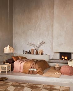 a bedroom with a bed, fireplace and rugs on the floor in front of it