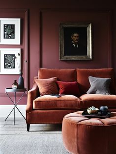 an orange couch and ottoman in a living room with pink walls, white trim and flooring