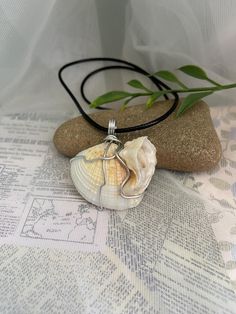 This simple but elegant necklace is made from a white seashell that is wire wrapped and hung on an 18" wax cord necklace with a 2" extension chain for adjusting the size. This shell has a unique shape to it and is just so beautiful! It makes the perfect addition to any summer outfit and any beach day! Orders within Canada are sent via oversized lettermail (no tracking) to keep shipping costs low. Tracking is available at the checkout for an extra fee.  Orders to the US are sent via tracked packe White Sterling Silver Shell Necklace For Gift, White Sterling Silver Shell Necklace As Gift, White Shell Necklace With Adjustable Cord, Sterling Silver Wire Wrapped White Necklace, White Shell Necklace With Adjustable Cord As Gift, Handmade White Silver-plated Wire Jewelry, White Sterling Silver Wire Wrapped Necklaces, White Sterling Silver Wire Wrapped Necklace, Sterling Silver White Wire Wrapped Necklace