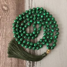 This Malachite Beaded Japa Mala Necklace is a traditional prayer necklace made from beautiful green Malachite beads. It is believed that using a Japa Mala during meditation and prayer can help calm the mind and deepen spiritual awareness. The benefits of using a Japa Mala include promoting mindfulness, increasing focus, and helping to connect with a higher power. The Malachite stone is known for its healing properties and is believed to protect the wearer from negative energies while promoting e Green Gemstone Beads Necklace For Healing, Green Round Beads Healing Necklace, Traditional Jade Necklaces For Meditation, Traditional Jade Necklace For Meditation, Traditional Green Necklace For Healing, Spiritual Malachite Beaded Necklaces, Spiritual Malachite Necklace For Healing, Spiritual Jade Beaded Necklace With Polished Beads, Spiritual Jade Beaded Necklaces With Polished Beads