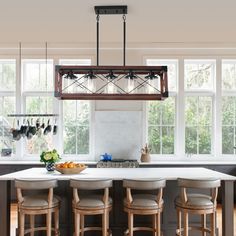 a kitchen island with four stools in front of it