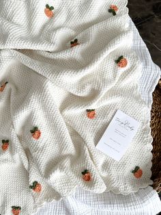 a white blanket with pineapples on it and a tag attached to the back