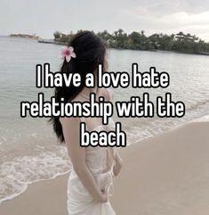 a woman in white dress standing on beach next to the ocean with text i have a love hate relationship with the beach