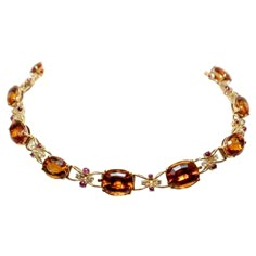 Semi-rigid choker necklace made in yellow gold with large oval-cut quartz (Citrines) alternating with intertwined links centered by two cabochon-cut rubies and two brilliant-cut diamonds. The necklace can be divided into two bracelets and a pendant. Approx. weight of stones: Quartz: 115,00 cts Diamonds: 1,60 cts, colour H, clarity VVS, Rubies: 4,00 cts 1950s Luxury Vintage Antique Gold Necklace, Luxury Orange Necklace With Natural Stones, Formal Citrine Necklace With Oval Shape, Oval Citrine Necklace For Formal Occasions, Drink Outfit, Mood Boards Fashion, Orange Quartz, Hand Jewelry Rings, Quartz Choker