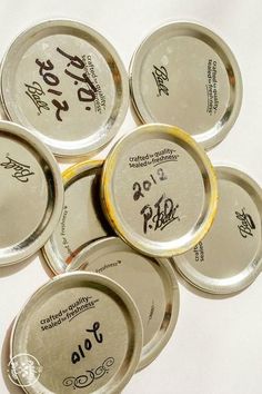 six empty tins with writing on them are arranged in a circle and have been placed together