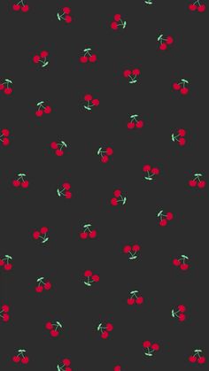 a black background with red cherries and green leaves on it's sides,