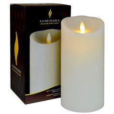 a white candle sitting in front of a box