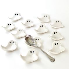 a spoon is surrounded by ghost shaped dishes