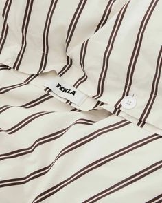 a white and black striped shirt with a tag on it's left chest pocket