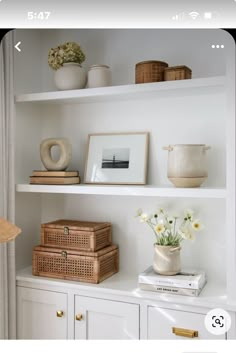 a white shelf filled with books and vases on top of it's shelves