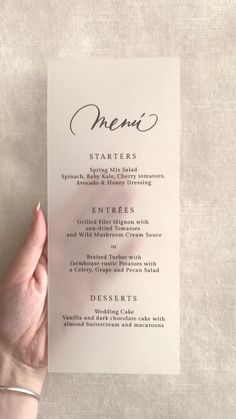 a person holding up a menu card with the word, menu written in cursive writing