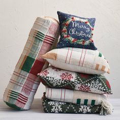 a stack of christmas pillows and blankets on top of each other