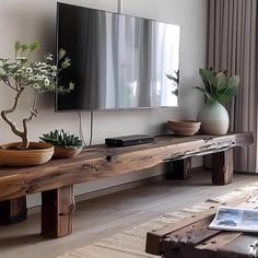 a living room with a large flat screen tv sitting on top of a wooden table