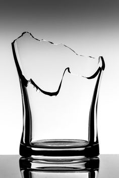 a black and white photo of a glass with water in it's bottom half