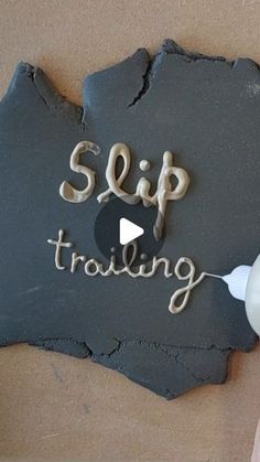 someone is using a toothbrush to paint the word'slip trolling'on a slate plaque