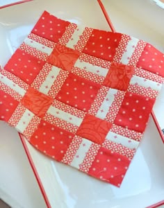 a red and white patchwork quilt on a plate