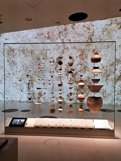 a display case with vases on the wall and in front of it is a cell phone