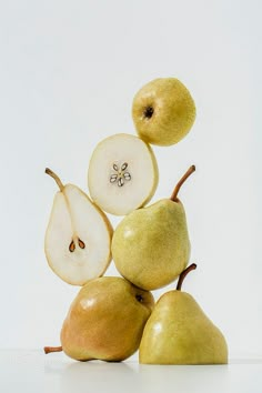 apples and pears stacked on top of each other in front of a white background