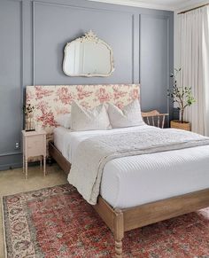 a bedroom with blue walls and white bedding