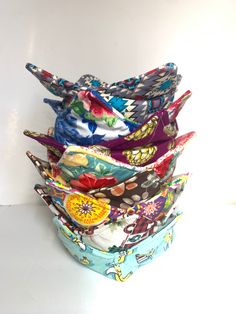 a stack of different colored cloths sitting on top of each other in front of a white wall