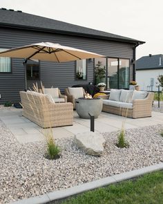 an outdoor patio with chairs, tables and an umbrella over the fire pit in front of it