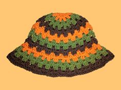 a crocheted hat with orange, green and brown trim