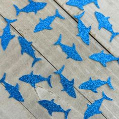 some blue glittered sharks on a wooden surface