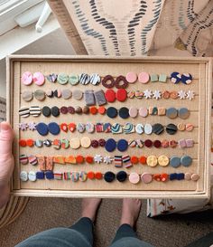 a person holding up a framed display with buttons on the bottom and side of it