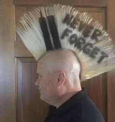 a bald man with a hair brush on top of it's head and words written on the back of his head