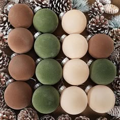 several different colored balls and pine cones on a table