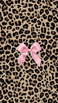 a pink bow sitting on top of a leopard print wallpaper with an animal pattern