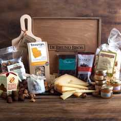 an assortment of cheeses and nuts in a wooden box