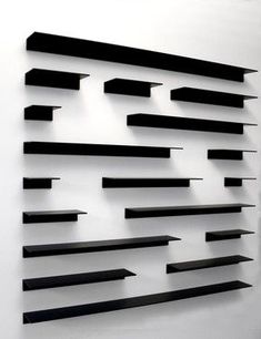 a white wall with black shelves on it