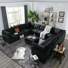 a living room with black couches and white rugs in front of a large window