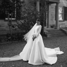 a woman in a wedding dress is standing outside