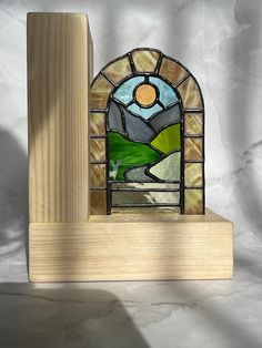 a stained glass window sitting on top of a wooden block