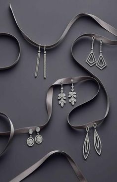 an assortment of silver jewelry on a gray background