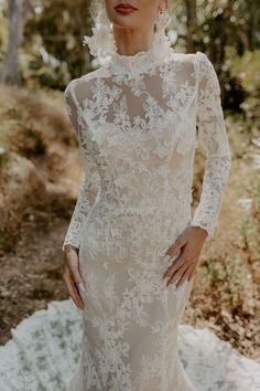 a woman in a white wedding dress posing for the camera with her hands on her hips