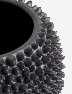 a black vase that has spikes on it