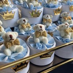 there are many small teddy bears in little boxes with bows on the bottom and gold trim around them